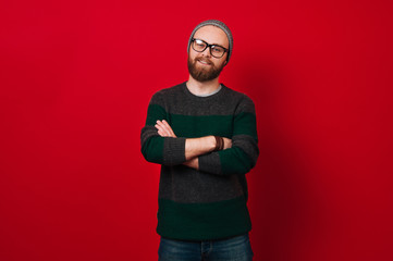 Fototapeta premium Portrait of cheerful bearded hipster man over red background