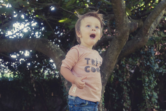 ni&ntilde;o con la boca abierta y cara de asombro en un jard&iacute;n
