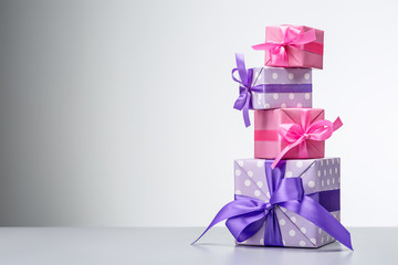 Set of vertical gift boxes decorated with ribbons and bows. Festive background. Copy space.