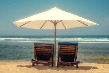 Beach chairs on the beach under a white umbrella. Location coast, sea. Concept vacation