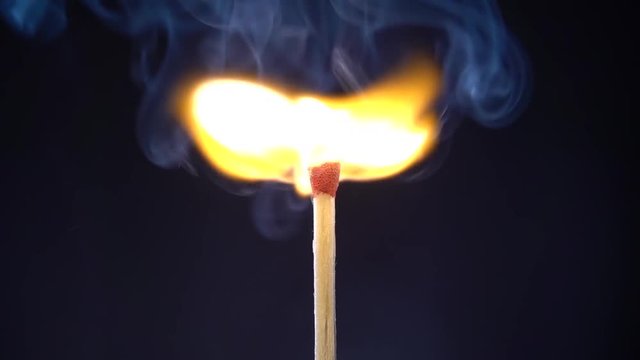 Striking match and burning on black background. Slow motion