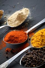 Various spices spoons on stone table.On dark concrete background.Herbs and spices on wooden table.  Top view with space for your text