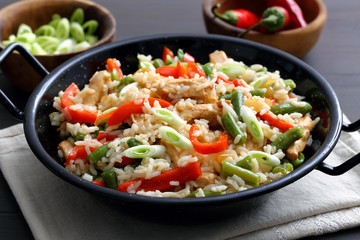 riso con verdure e carne arrosto in tagame di metallo su sfondo grigio