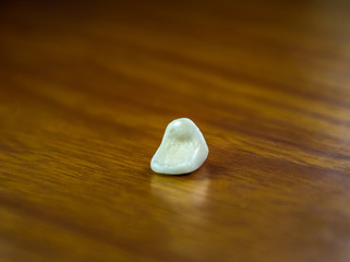 Tooth, metal ceramic crown on the table. Denture made of metal ceramics.