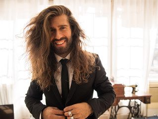 young man with long hair wearing a suit © marc