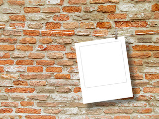 Blank square instant photo frame against orange weathered brick wall background