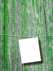 Blank square instant photo frame against green weathered wooden background