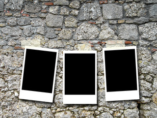 Three blank rectangular instant photo frames on old weathered stone wall background