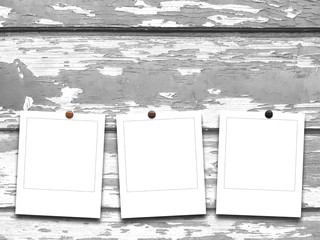 Three blank square instant photo frames on scratched wooden boards background