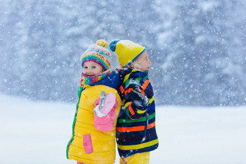 Fototapeta na wymiar Kids playing in snow. Children play in winter.
