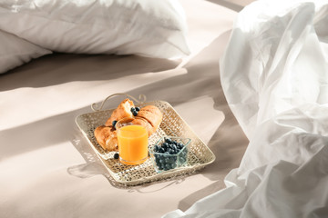 Fototapeta na wymiar Tray with delicious breakfast on bed