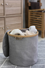 Fototapeta na wymiar Laundry basket with dirty towels on floor in room