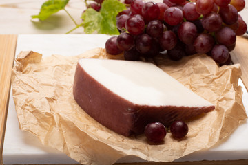 Traditional Spanish cheese, Murcian wine cheese from goat milk with rind washed in red wine, served with fresh ripe grapes