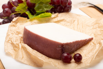 Traditional Spanish cheese, Murcian wine cheese from goat milk with rind washed in red wine, served with fresh ripe grapes