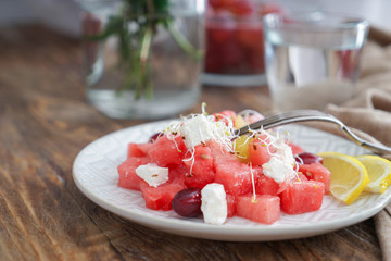 Plate with delicious watermelon salad on wooden table