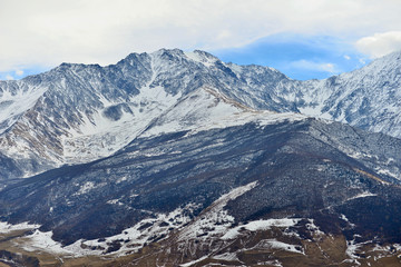 Fototapeta na wymiar Rocky snow-capped mountains over the village of Fiagdon in North Ossetia.