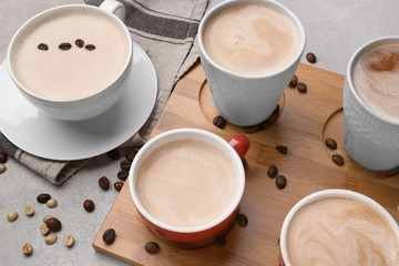 Many cups with tasty aromatic coffee on grey table