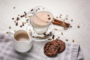 Cup and jug with tasty aromatic coffee and cookies on white table