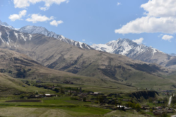 Fototapeta premium Rocky snow-capped mountains over the village of Fiagdon in North Ossetia.