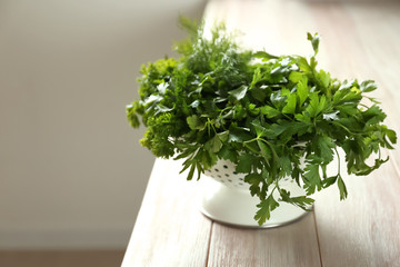 Fototapeta premium Colander with fresh aromatic herbs on wooden table