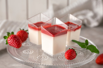 Glasses with tasty strawberry panna cotta on stand
