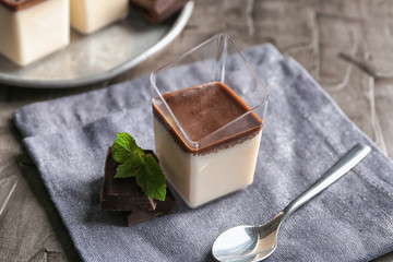Glass with tasty chocolate panna cotta on grey table