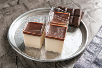 Glasses with tasty chocolate panna cotta on metal tray