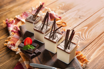 Glasses with tasty chocolate panna cotta on wooden table