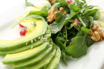 Delicious fresh salad with walnuts on plate, closeup