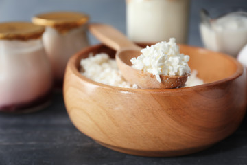Bowl with cottage cheese on wooden table