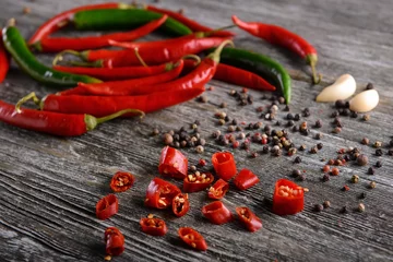 Gardinen Chilischoten Fresh chili peppers with spices on wooden table  © Pixel-Shot