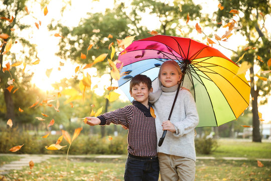 Cute little children with colorful umbrella in autumn park