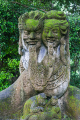 estatuas cubiertas de vegetación en un bosque de ubu unidas por las lenguas