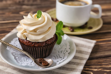Tasty chocolate cupcake on wooden table