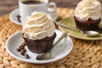 Tasty chocolate cupcake on wicker mat
