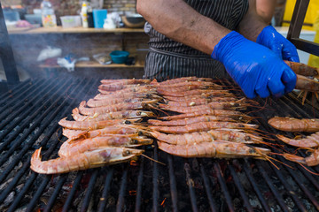 Cooking fresh king's shrimp on a grill on a foodfest.