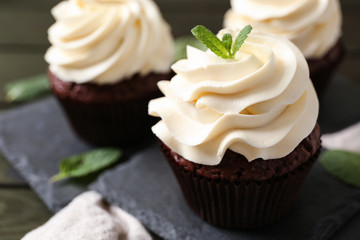 Tasty chocolate cupcake on slate plate, closeup