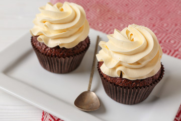 Tasty chocolate cupcakes on plate