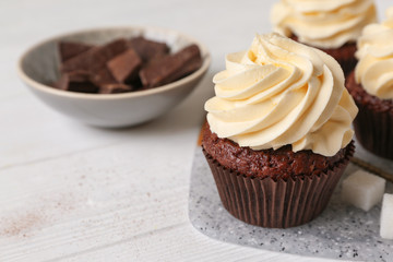 Tasty chocolate cupcake on white table