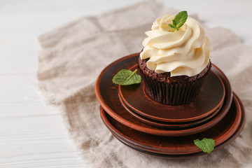 Tasty chocolate cupcake on stack of plates