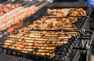 Assorted delicious grilled meat over the coals on barbecue.