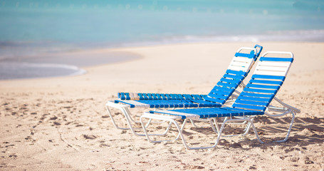 White lounge chairs on a beautiful tropical beach at Maldives