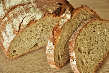 Baked wheat bread, half and two slices of sliced