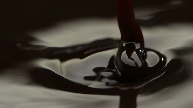 Slow motion of pouring melted dark chocolate.
