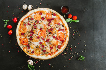 Tasty meat pizza with various ingredients on black background