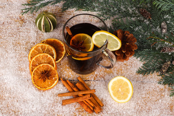 Obraz na płótnie Canvas christmas tea or mulled wine on wooden table with snow - christmas background