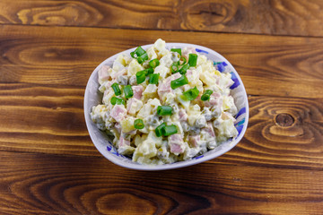 Traditional Russian festive salad Olivier on wooden table. Top view