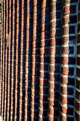 Wavy brown brick wall at an angle with a chain in the corner