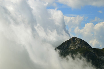 High mountain peak immersed in thick clouds