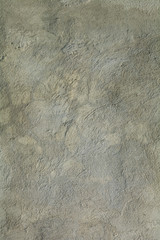 Grey and light brown plaster wall with pores and crack
